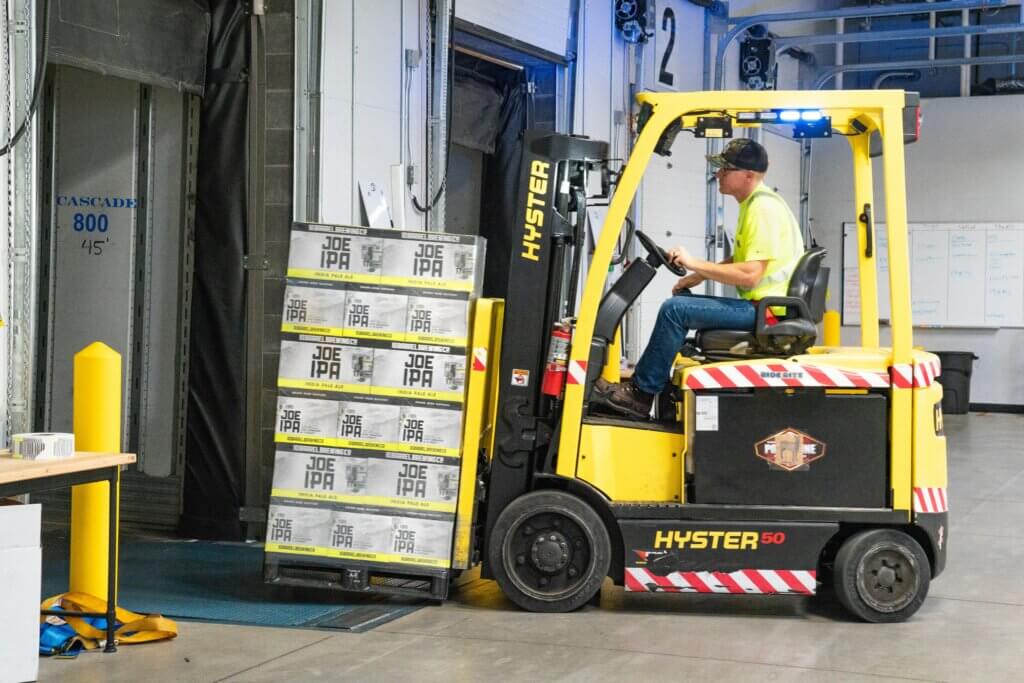 Forklift with a pallet of Joe IPA beer driving towards gate
